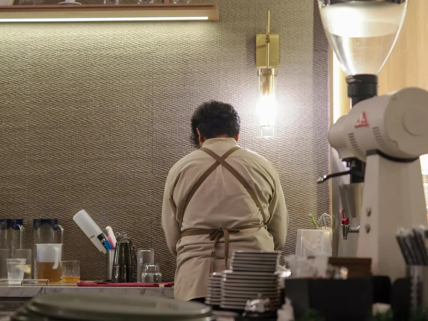 A barista making drinks behind a café counter.