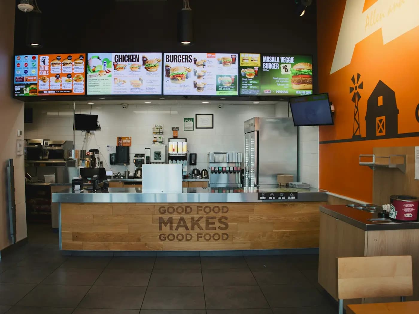 A quick-service counter with digital menu boards above it.