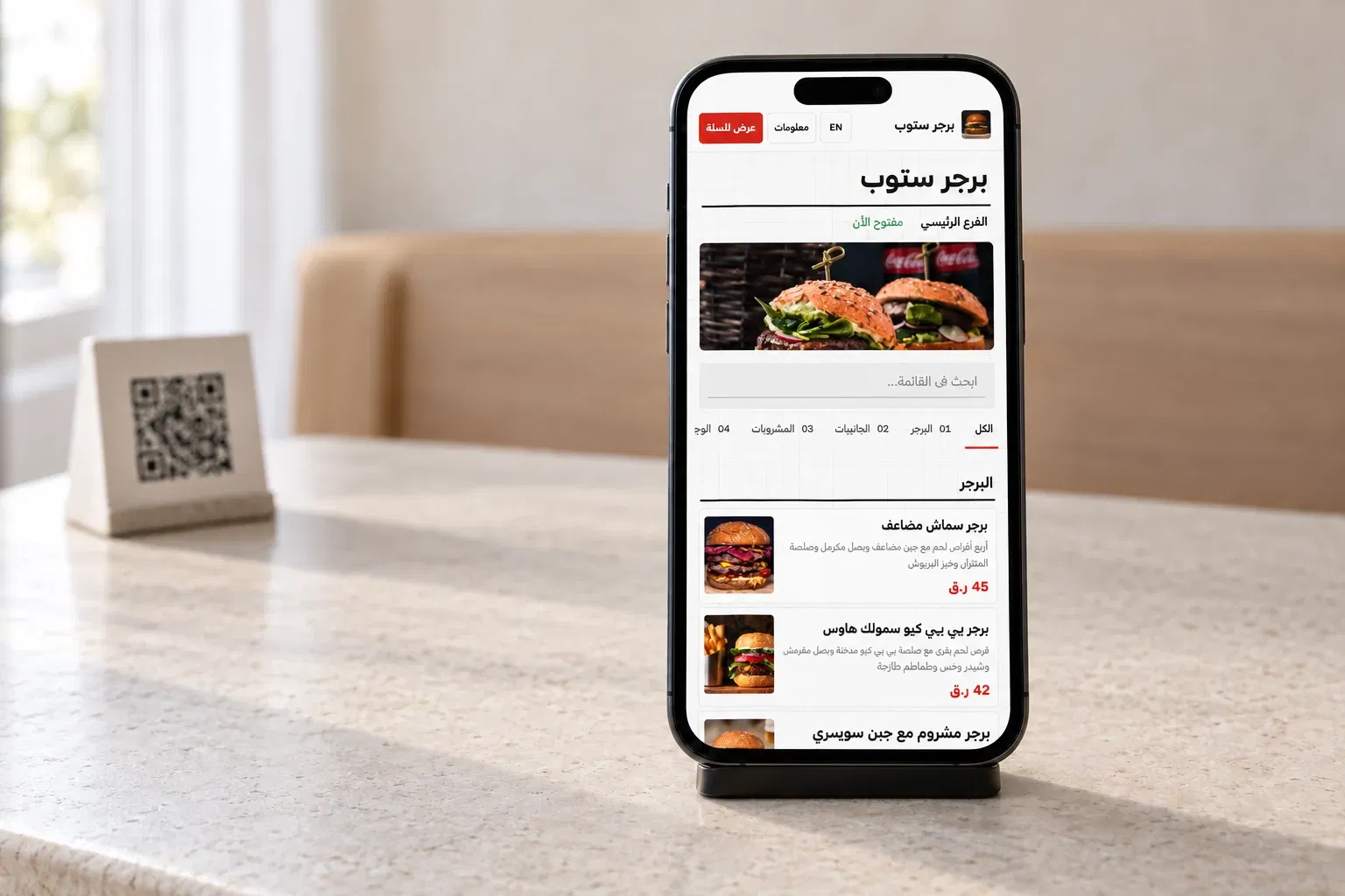 قائمة DashDine العربية الفعلية على هاتف ضيف بجوار رمز QR في مشهد مطعم توضيحي